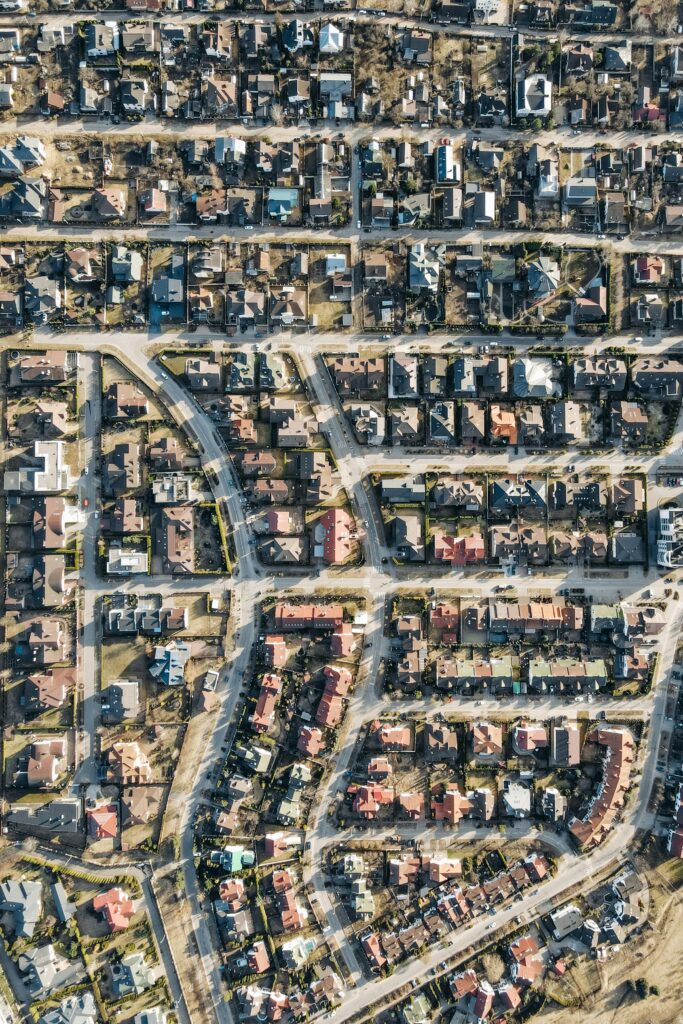 High-angle aerial view of a dense suburban neighborhood with organized streets and houses.